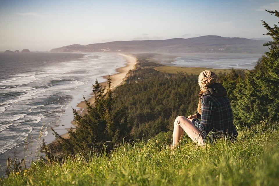 Hiker on hill overlooking ocean
