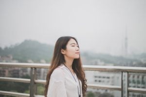 relaxed woman standing with eyes closed