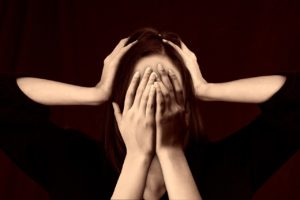 woman with hands covering face