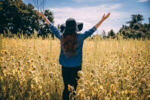 a woman filled with gratitude, arms upraised