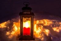 Candle in a lantern outside in the snow