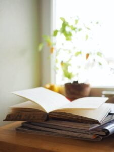 open book on top of a stack of magazines