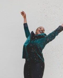 woman with arms raised celebrating she's already enough