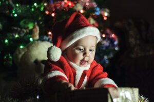 an excited baby opening a present