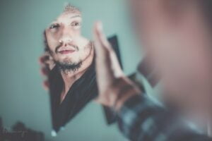 man looking in a mirror at his self-concept