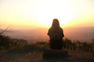 Woman meditating at sunrise