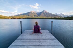 Woman sitting on a dock, contemplating her True Self