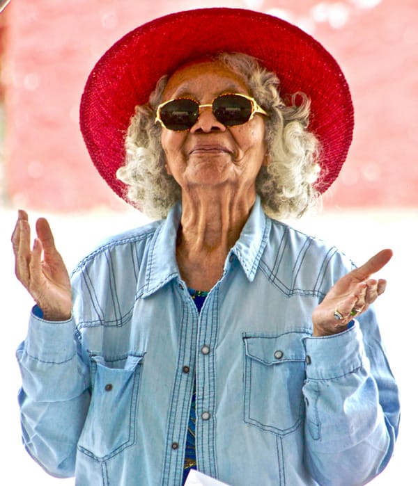 female senior red had with hands upraised
