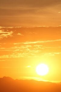 A glowing yellow and orange sunset with shimmering clouds