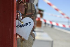 White, heart-shaped podlock with the word 'thanks' as a symbol of gratitude