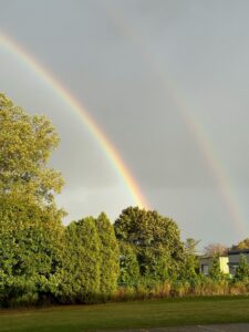 Rainbow appearing after rain over a natural landscape, symbolizing hope, transformation, and inner light